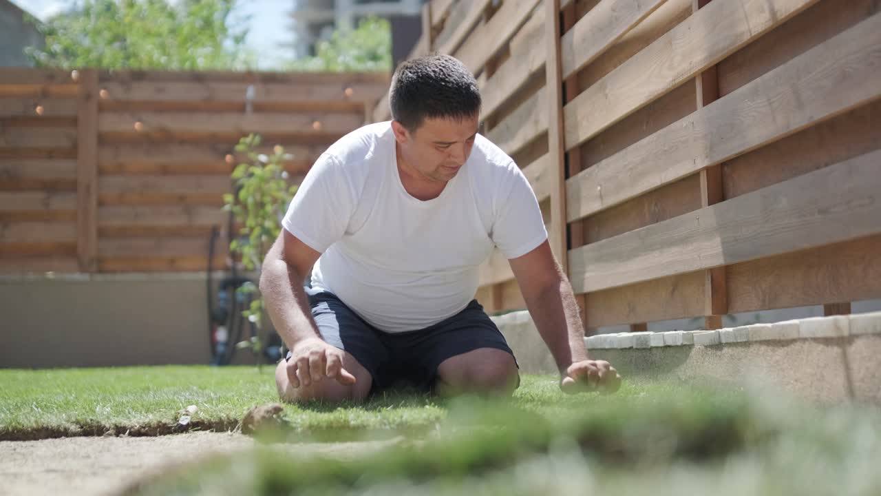 전문 정원사에 의해 설치 된 새로운 자연 잔디 잔디의 롤.