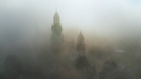 Aerial-view-of-Wawel-Castle-during-foggy-sunrise,-Krakow,-Poland