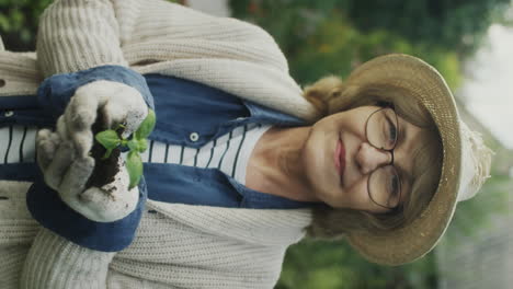 senior woman gardening and holding a young plant