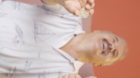 Vertical-video-of-Old-man-holding-bitcoin-and-showing-it.