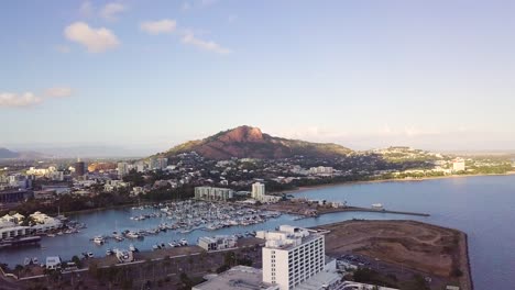 drone rising to reveal townsville city and castle hill on a sunny morning