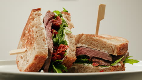 delicious beef sandwich with arugula and sun-dried tomatoes