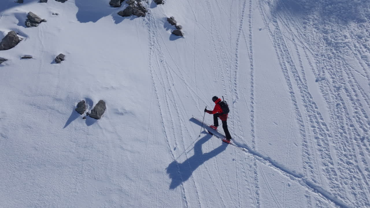 A professional skier hikes up a steep ridge in Verbier, then drops into an epic freeride descent. Pure adventure skiing in deep snow, dramatic terrain, and breathtaking alpine scenery.