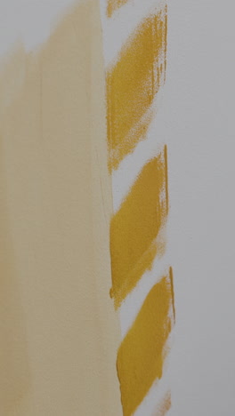 painting a wall yellow with a paint roller