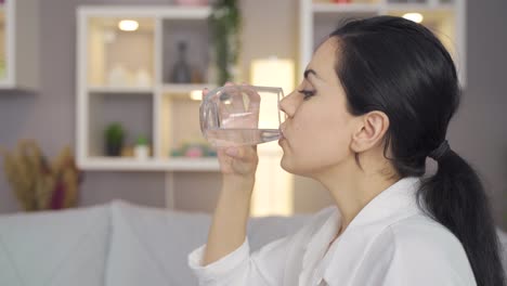 Woman-drinking-water-at-home.