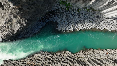 turquoise river running through white rock formations, aerial directly above