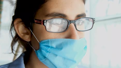 portrait close up female doctor puts on protective face mask