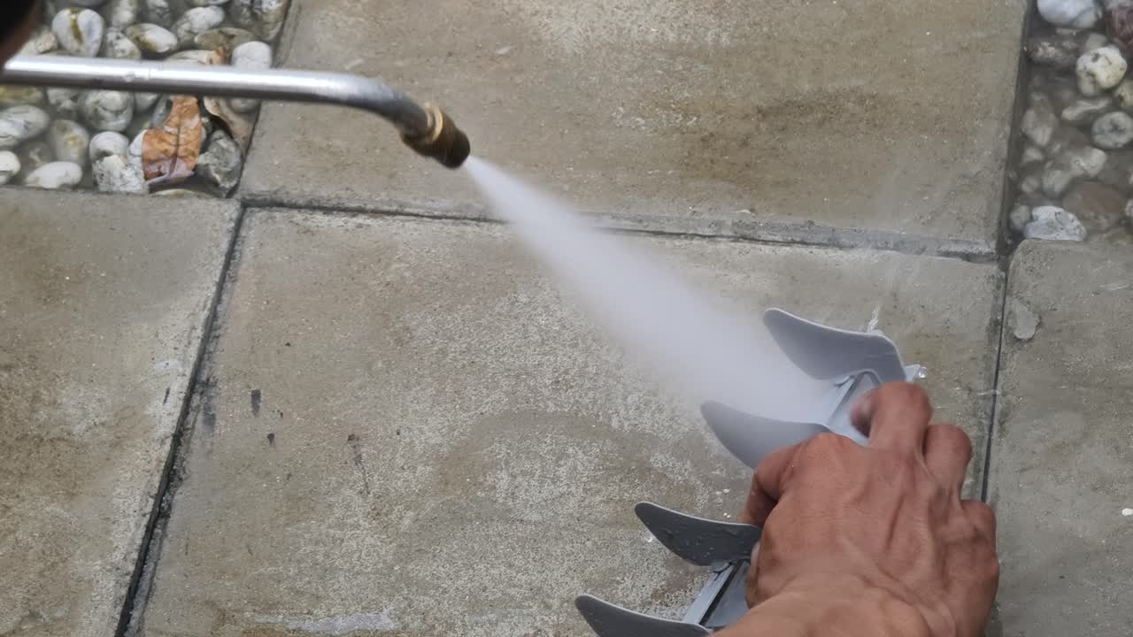 Cleaning a gray plastic part with a pressure washer