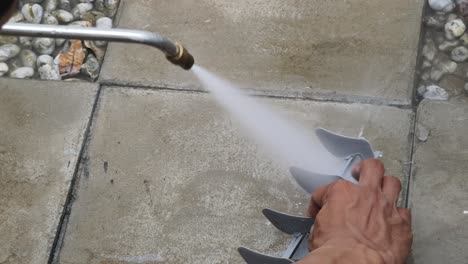 cleaning a gray plastic part with a pressure washer