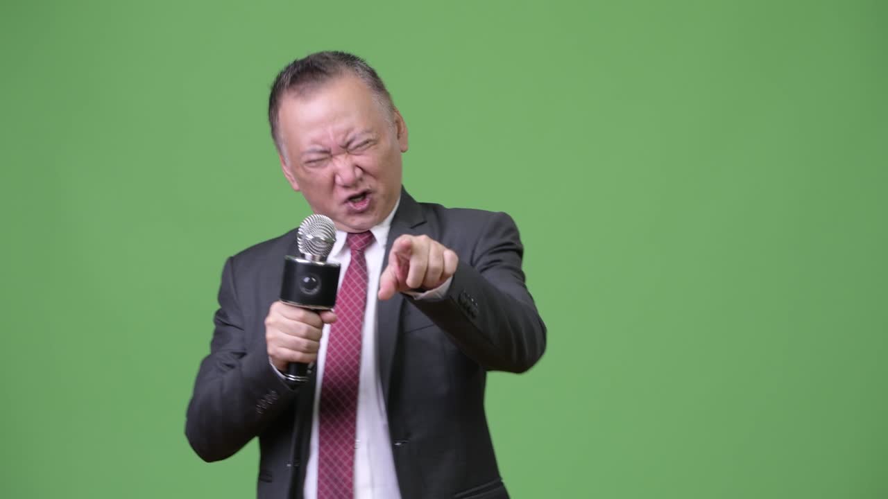 마이크를 사용하는 성숙한 일본 사업가