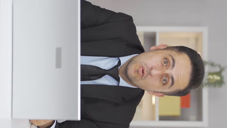 vertical video of home office worker man says wow to camera.