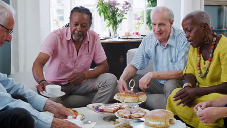 group of senior friends enjoying afternoon tea at home together