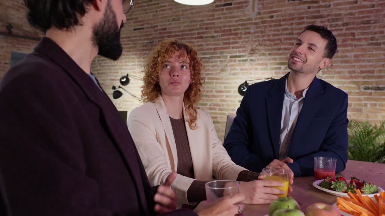 People talking at an office with snacks and juice