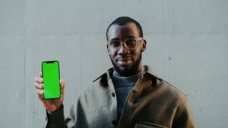 man holding green screen phone