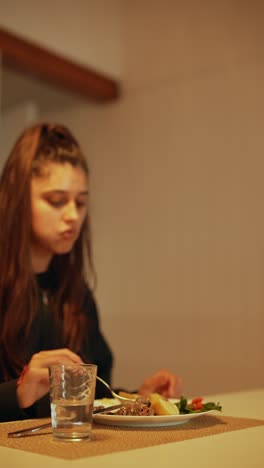 woman eating a meal in a kitchen