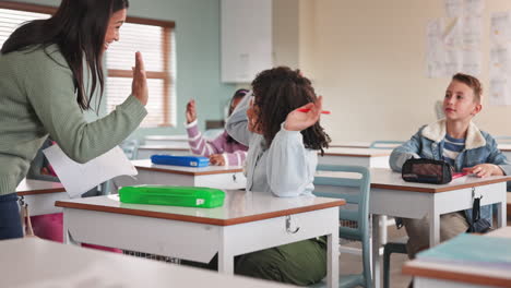Teacher giving high five to student in classroom