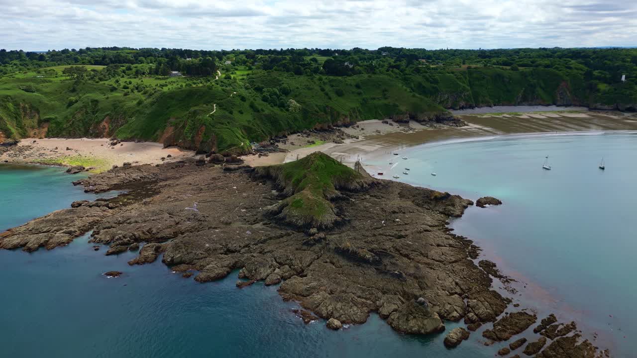 Aerial shot pulling back from Gwin Zegal's coastline, revealing rocky waters, shoreline, and surrounding vegetation -France