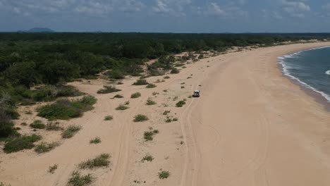 aerial over beach coastline at edge of yala national park in sri lanka with 4x4 driving off