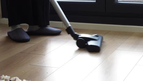 woman vacuuming hardwood floor in slippers