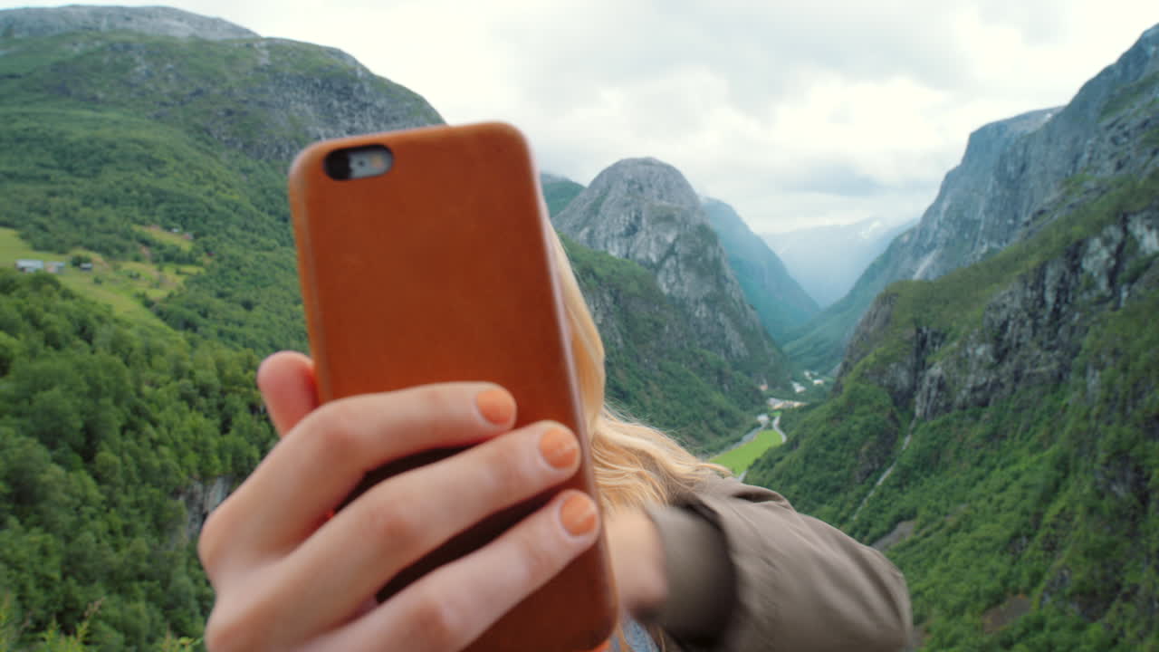 mujer feliz tomando selfies en los fiordos noruegos