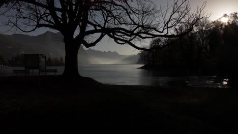 serene morning at walensee, switzerland, with mist over lake and sun rays illuminating mountains, camera slowly pushes in to peaceful beauty of landscape.