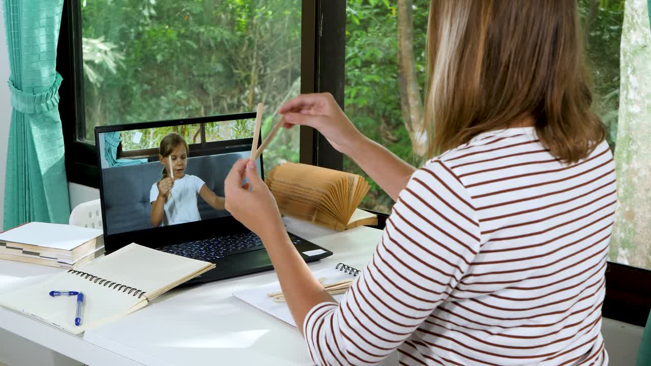 el maestro tiene una lección de educación a distancia por computadora portátil con una niña de la escuela
