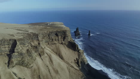 panorama of reynisdrangar basalt sea stacks with calm blue sea in summer near vik village in iceland