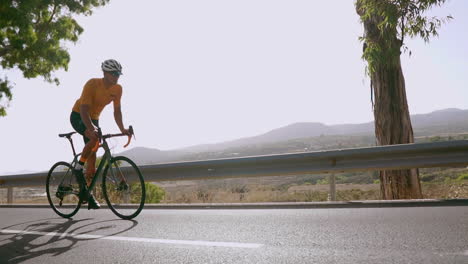 cycling on a road bike, a man enjoys outdoor exercise on an unoccupied morning road. the essence of extreme sports is showcased, beautifully portrayed in slow motion