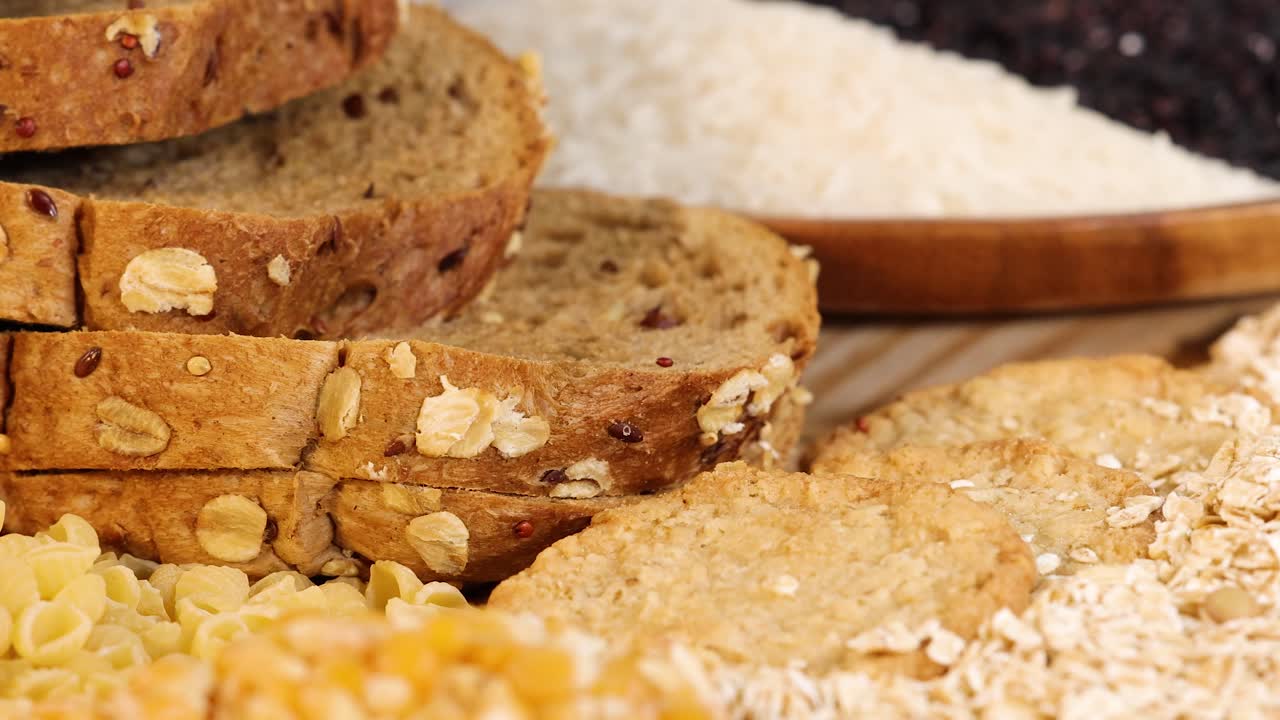 Close-up of various grains and breads arranged on a table, showcasing texture and color under bright lighting