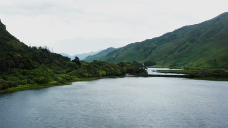 aerial dolly in shot of a wild forest and lake nearby the kylemore abbey