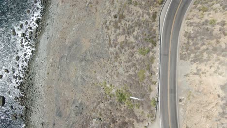 A-slowly-rising-aerial-of-a-part-of-Highway-1-on-the-Pacific-Ocean-coastline-in-California,-USA,-during-a-bright-and-sunny-afternoon