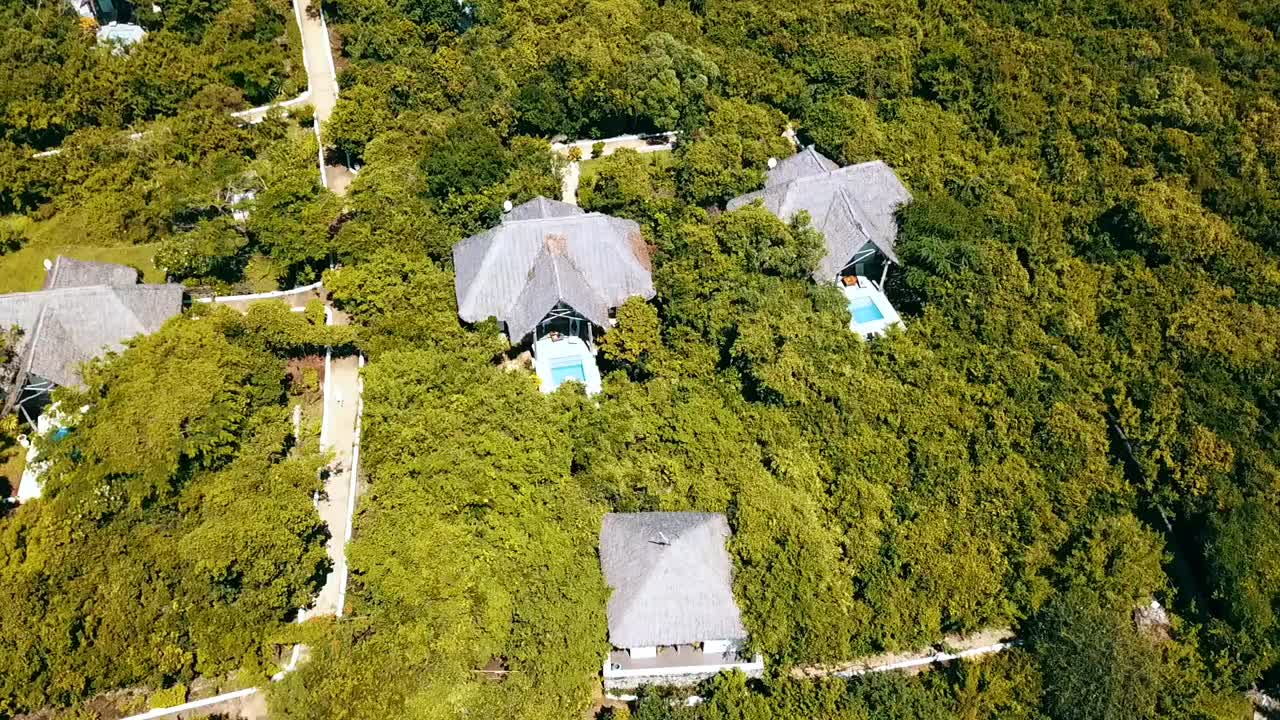 2019년 아프리카 탄자니아의 잔지바르에서 정글 파라다이스에 있는 럭셔리 풀 빌라의 드론 샷을 천천히 위로 기울이면 1080, 60p에서 philipp marnitz에서 촬영된 시네마틱 자연 공중 촬영