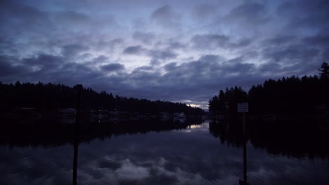 blaue stunde zeitraffer des sonnenaufgangs über der wollochet bay in der nähe von gig harbor, washington, strömende wolken, violetter bis strahlend weißer himmel, spiegelung auf dem wasser