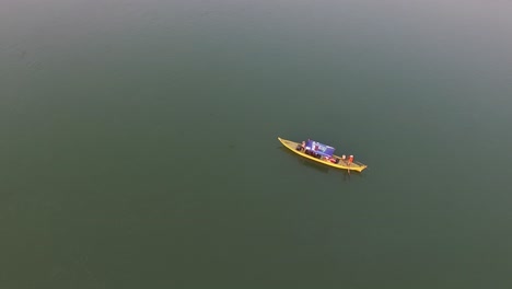 a boat in cambodia smoothly sailing over the calm waters of mekong river - aerial shot