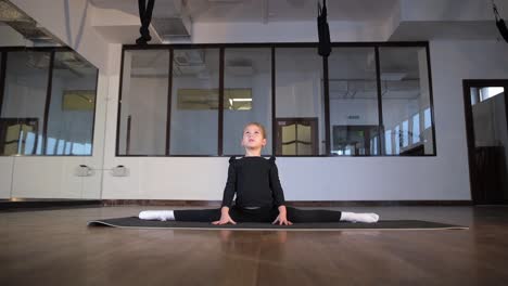 young girl practicing ballet stretches in a dance studio