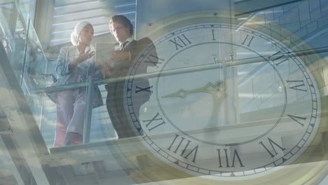 clock animation over business people discussing work on glass balcony