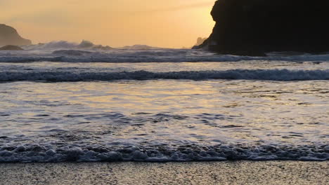 rolling waves coming on shore during sunset at the oregon coast