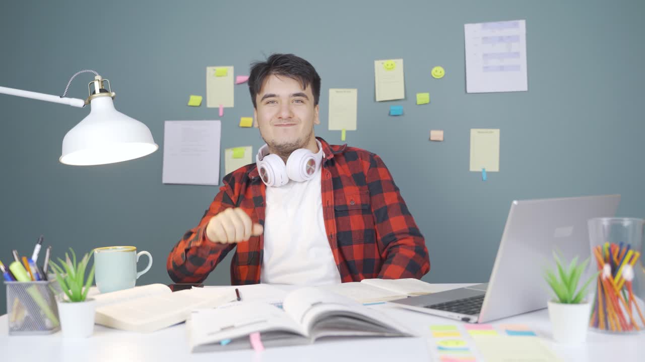 un estudiante masculino saludando a la cámara.