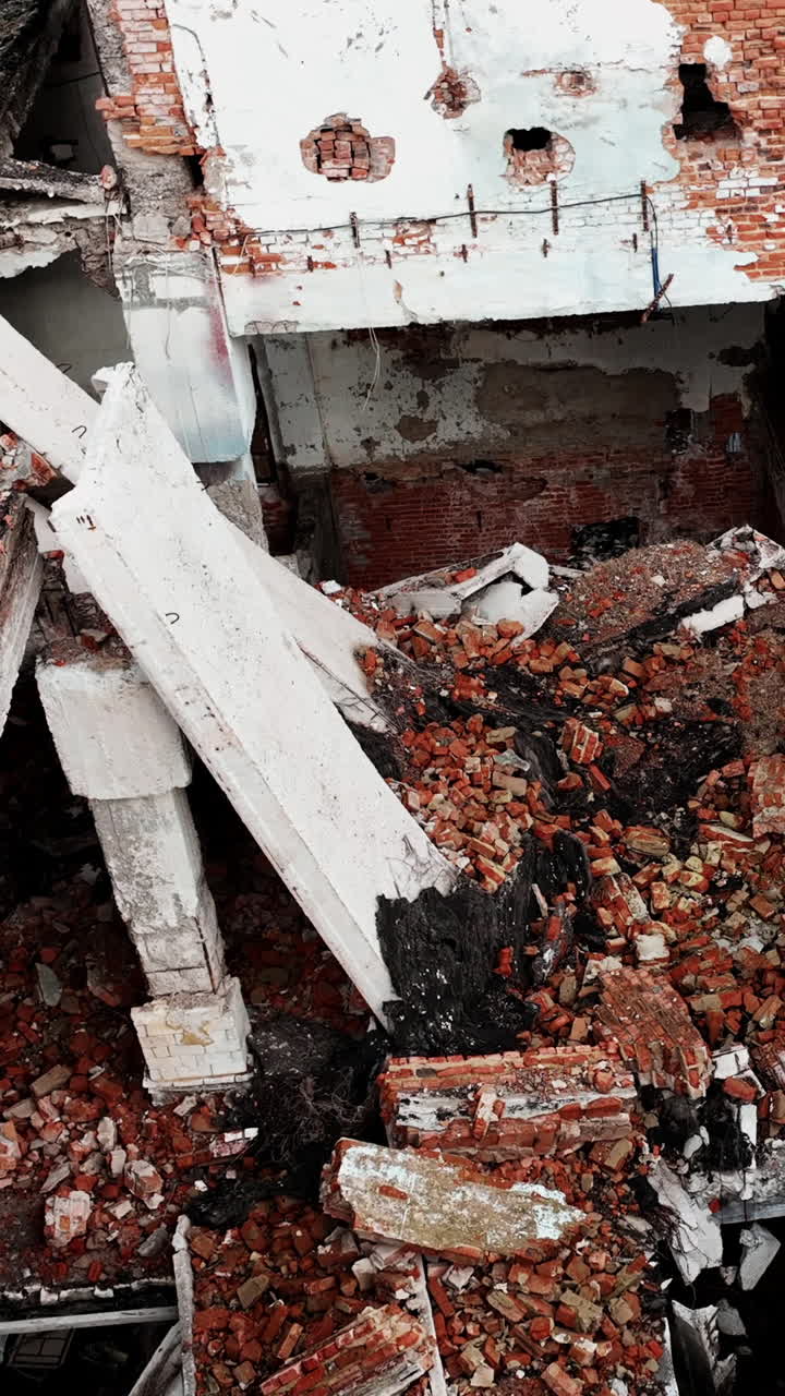 Ruins left from the building resulting from an earthquake. A huge pile of bricks and concrete among the wall leftovers. View from above. Vertical video
