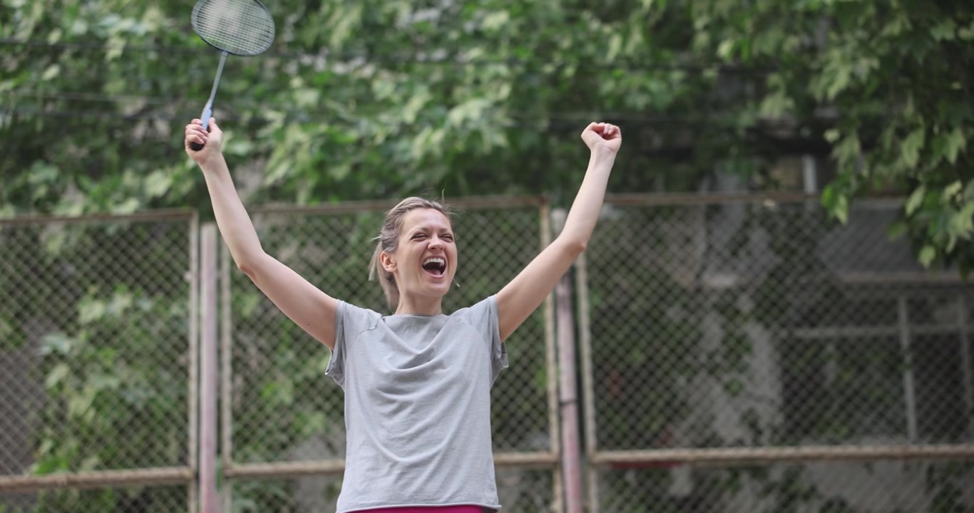 Female badminton player celebrates victory on urban court