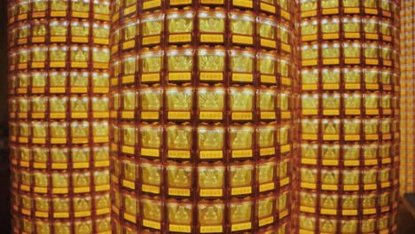 symmetrical close-up of golden buddha statues glowing in individual illuminated niches at ciyou temple in taiwan, symbolizing devotion, peace, and spiritual reverence in a sacred buddhist space