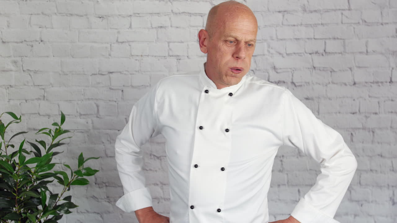 피곤하고 스트레스를 받은 요리사가 주방에서 휴식을 취합니다.