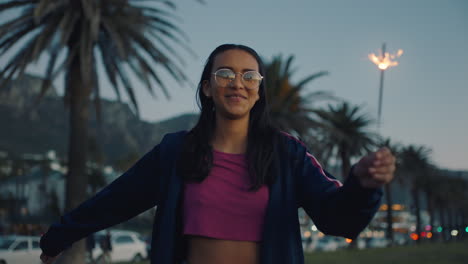hermosa adolescente con bengalas bailando en la playa al atardecer celebrando divirtiéndose celebración del día de la independencia con fuegos artificiales disfrutando de la libertad del 4 de julio