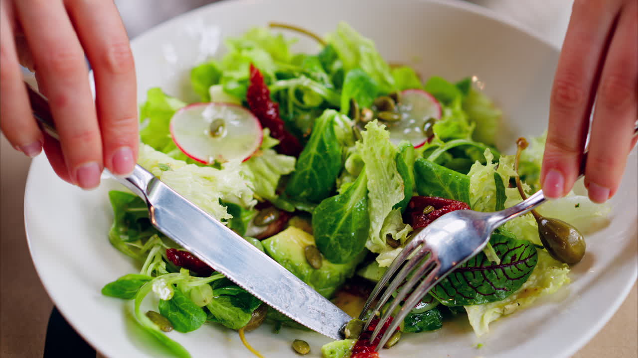 Woman eating a fresh salad at a restaurant