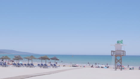 a quiet day on barbate beach with a green flag