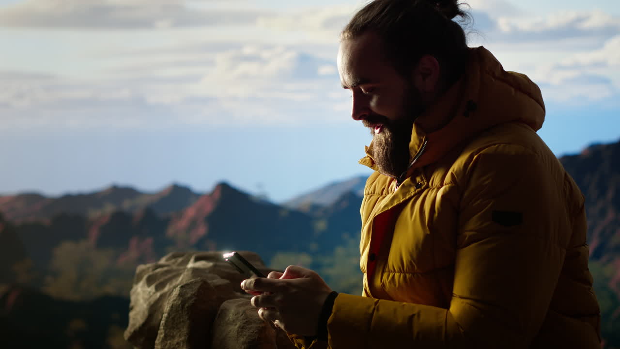el excursionista disfruta de un momento de tranquilidad en las montañas desplazando la aplicación de teléfono