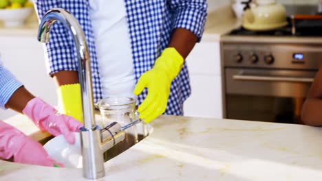 Family-washing-utensils-in-kitchen-sink