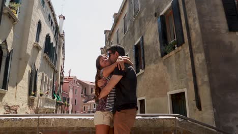 young tourist couple hugging in a romantic way in a bridge in venice, italy
