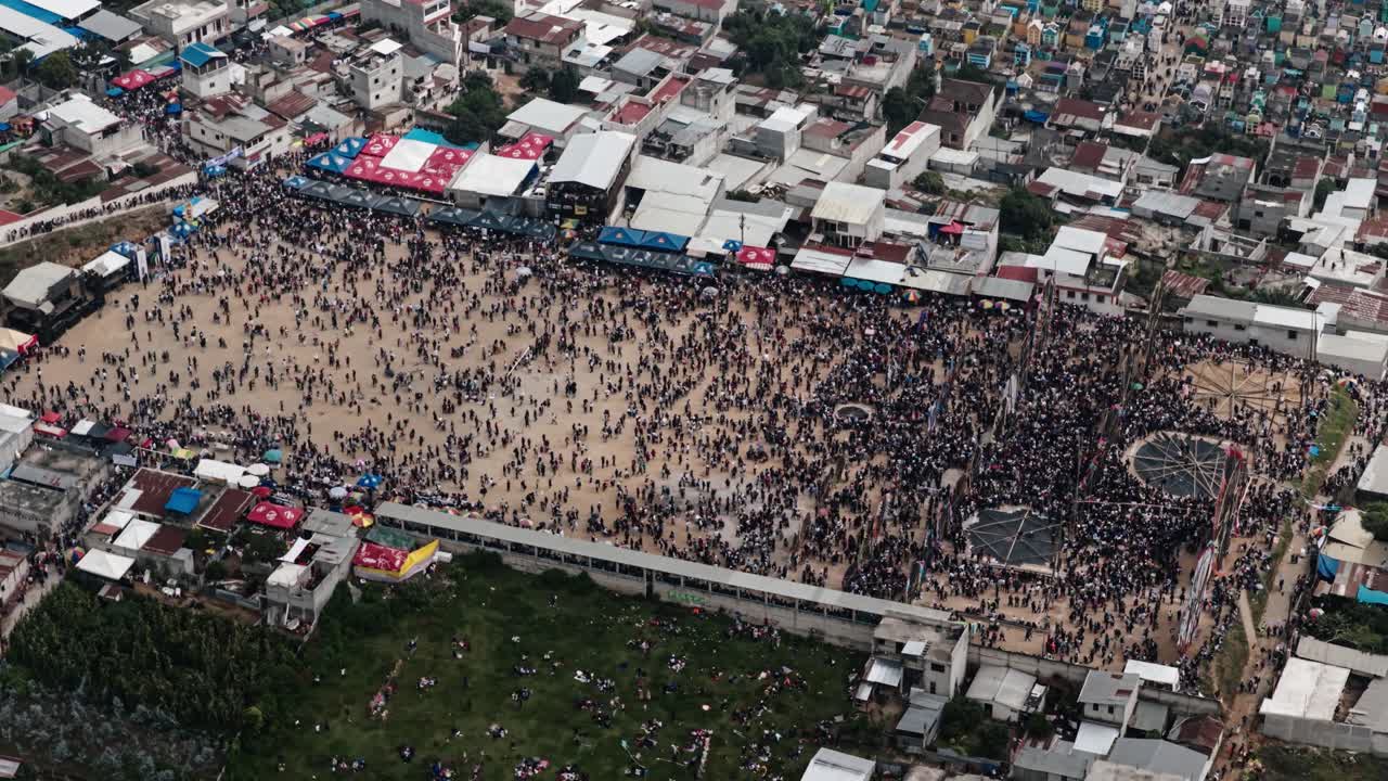 Aerial of Sumpango festival crowds and nearby colorful cemetery in Guatemala
