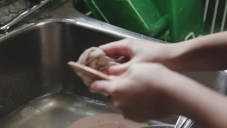 dirty plates being scrubbed by hand